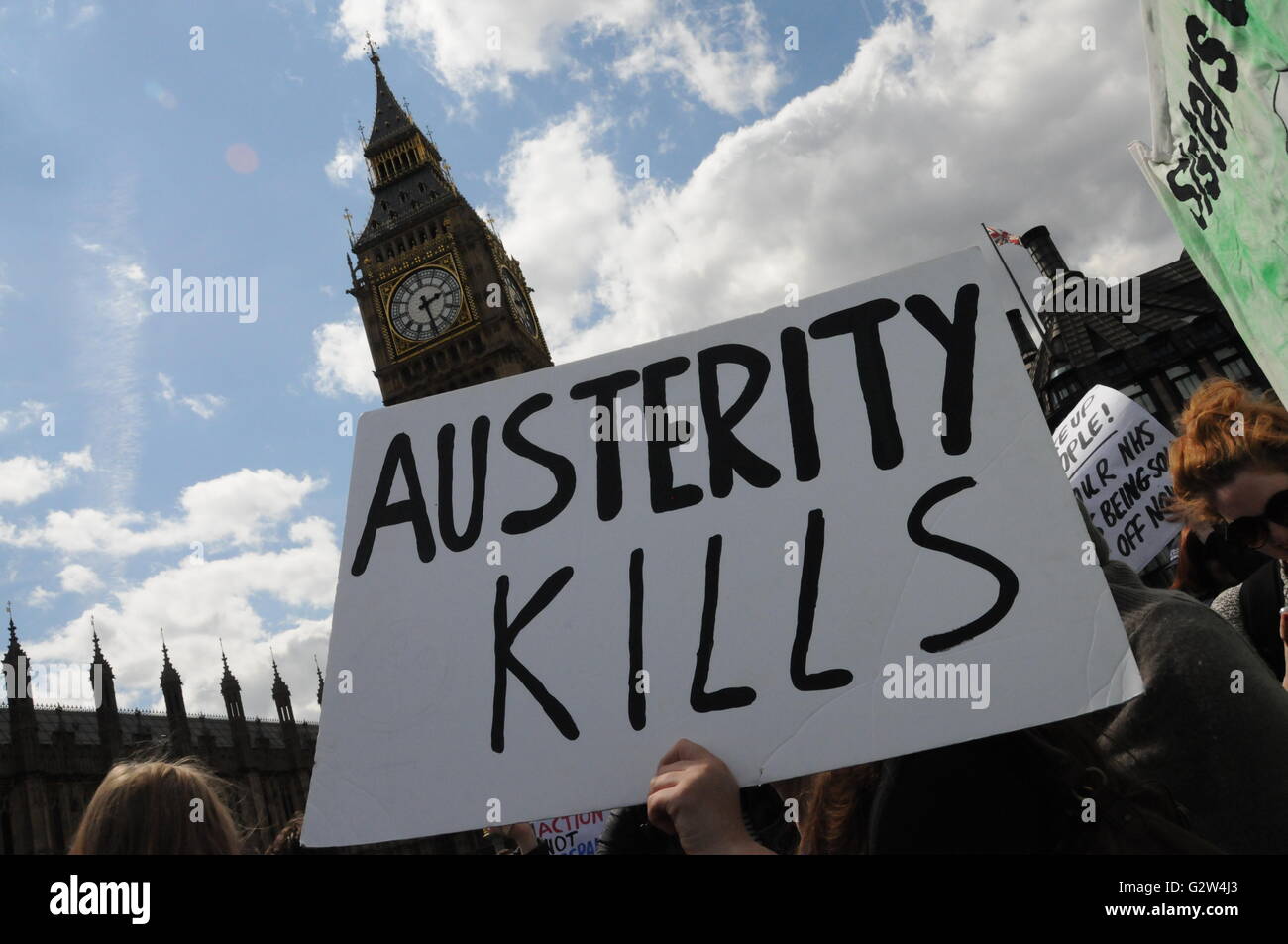 Demonstranten gegen Sparpolitik halten ein Plakat vor Big Ben, London. Stockfoto
