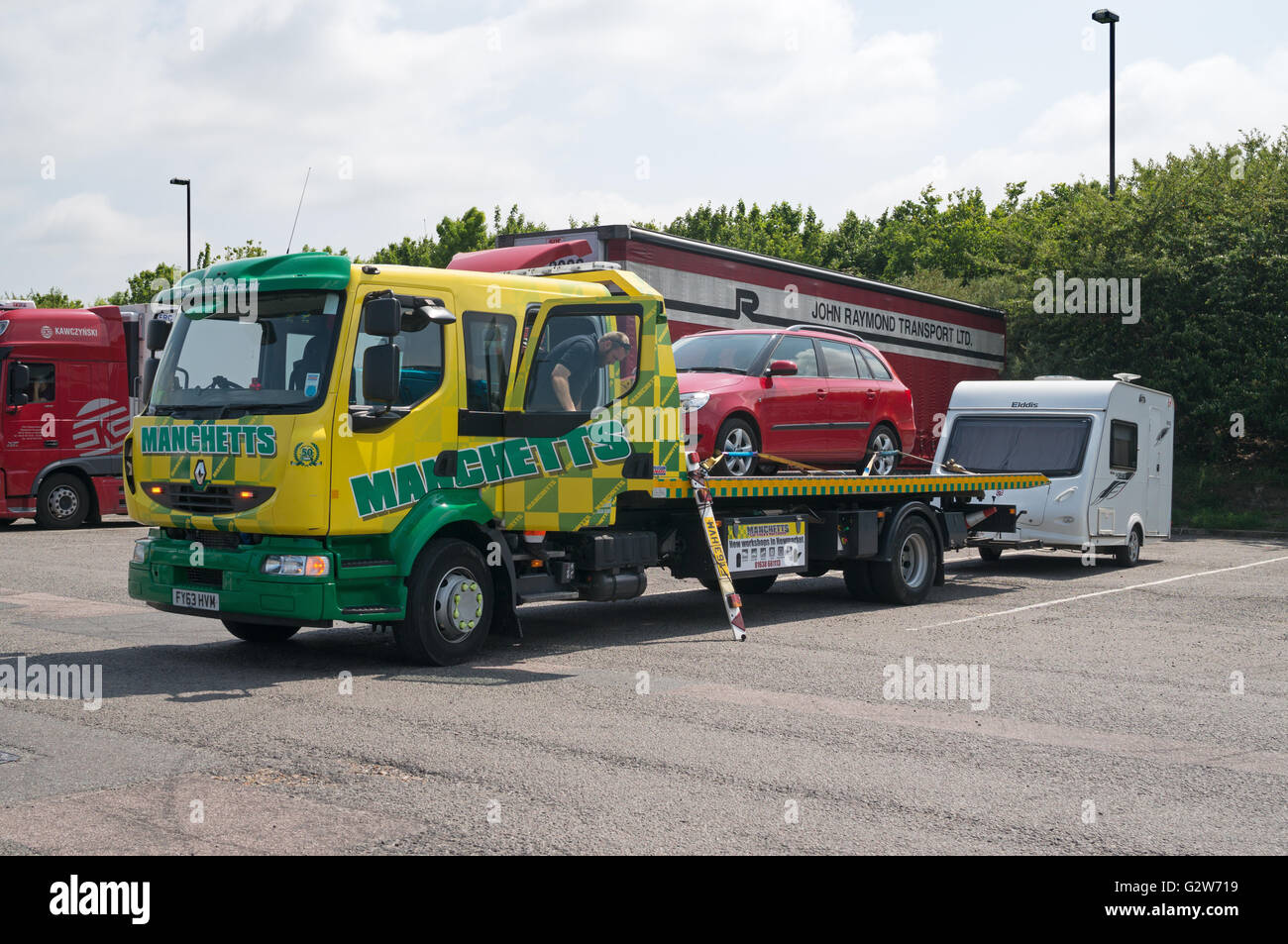 Unten gebrochen Auto auf Manchetts Renault slidebed Rettung Lkw mit Wohnwagen im Schlepptau, Autobahnraststätte, England, Großbritannien Stockfoto
