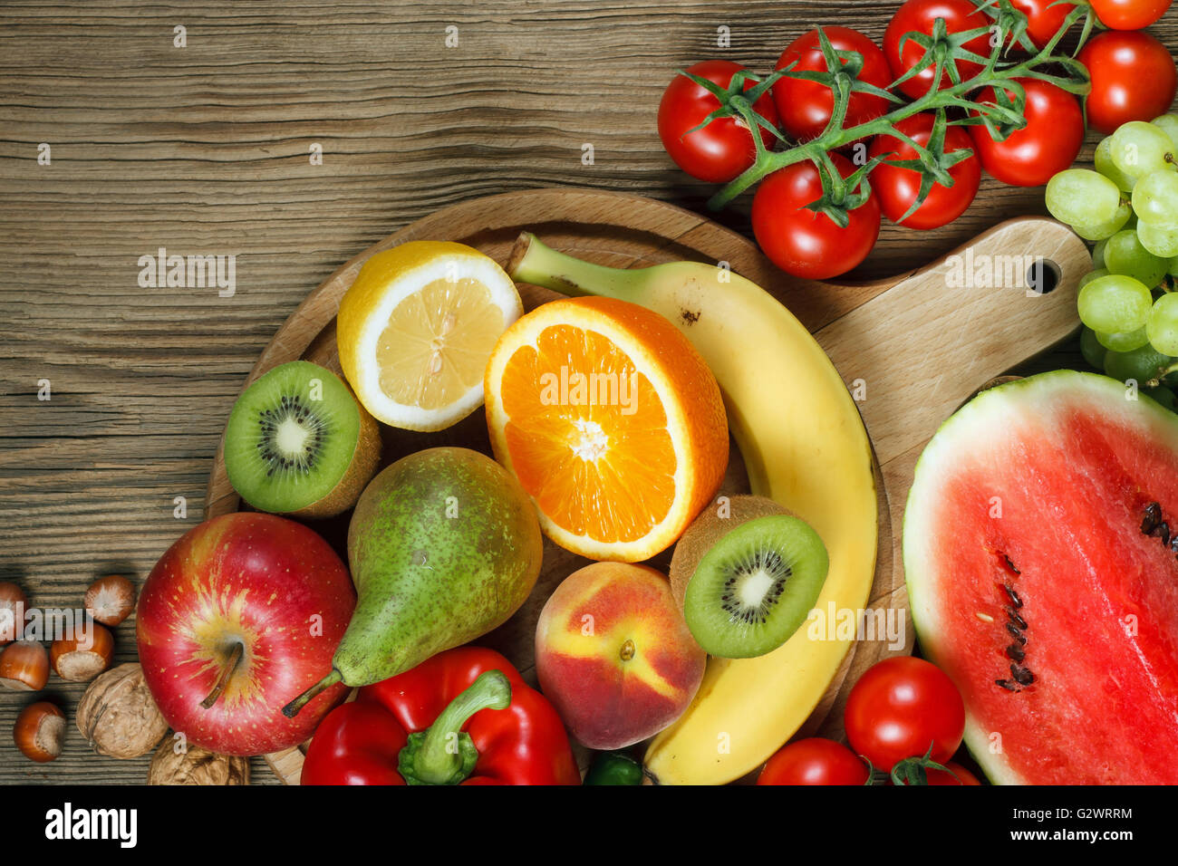 Vitamine in Obst und Gemüse. Natürliche Produkte, die reich an Vitaminen wie Orangen, Zitronen, Paprika, Kiwi, Tomaten, Bananen, Erbsen Stockfoto