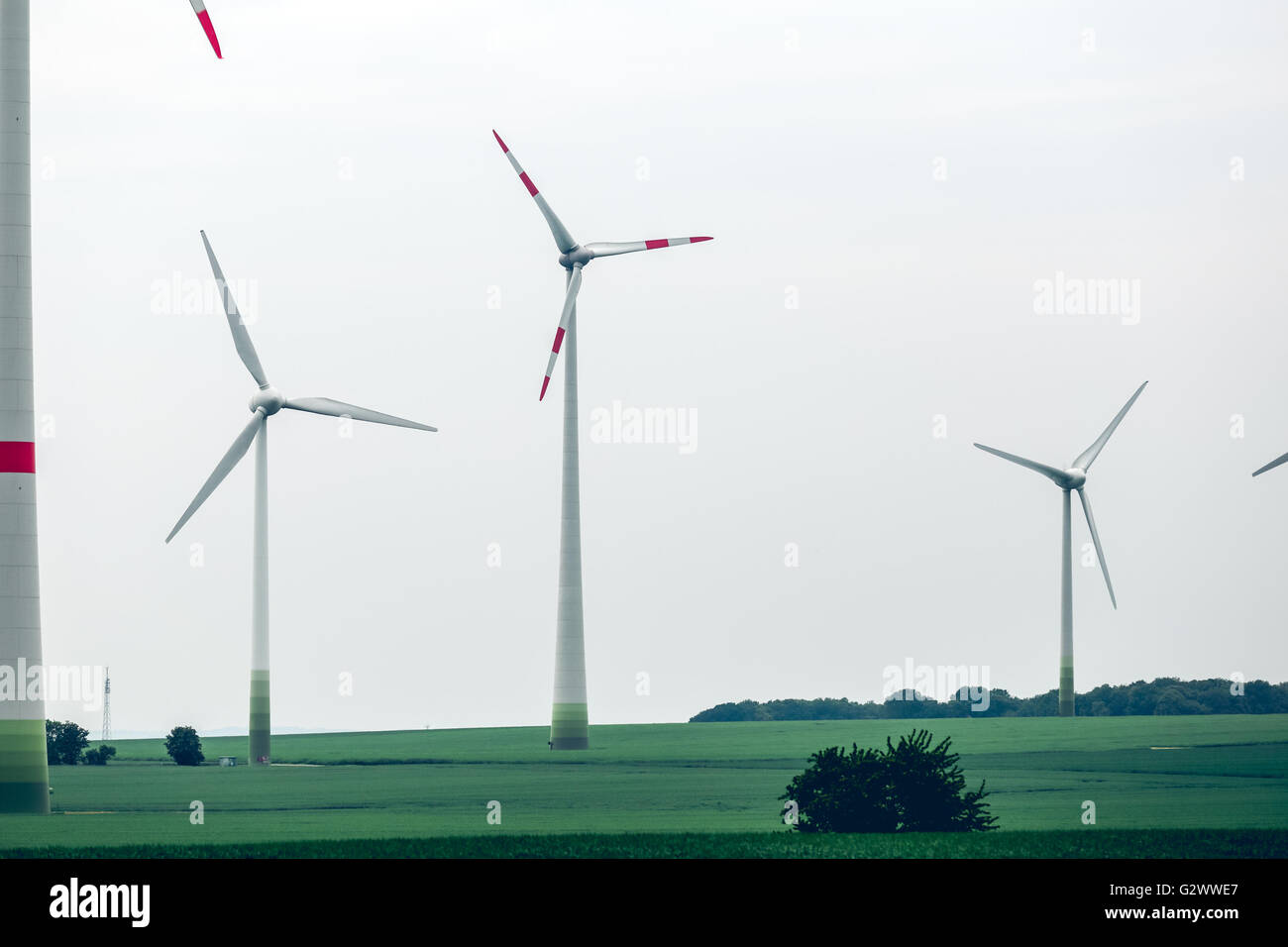 Metall-ökologische Windmühlen stehen in einem grünen Feld Stockfoto