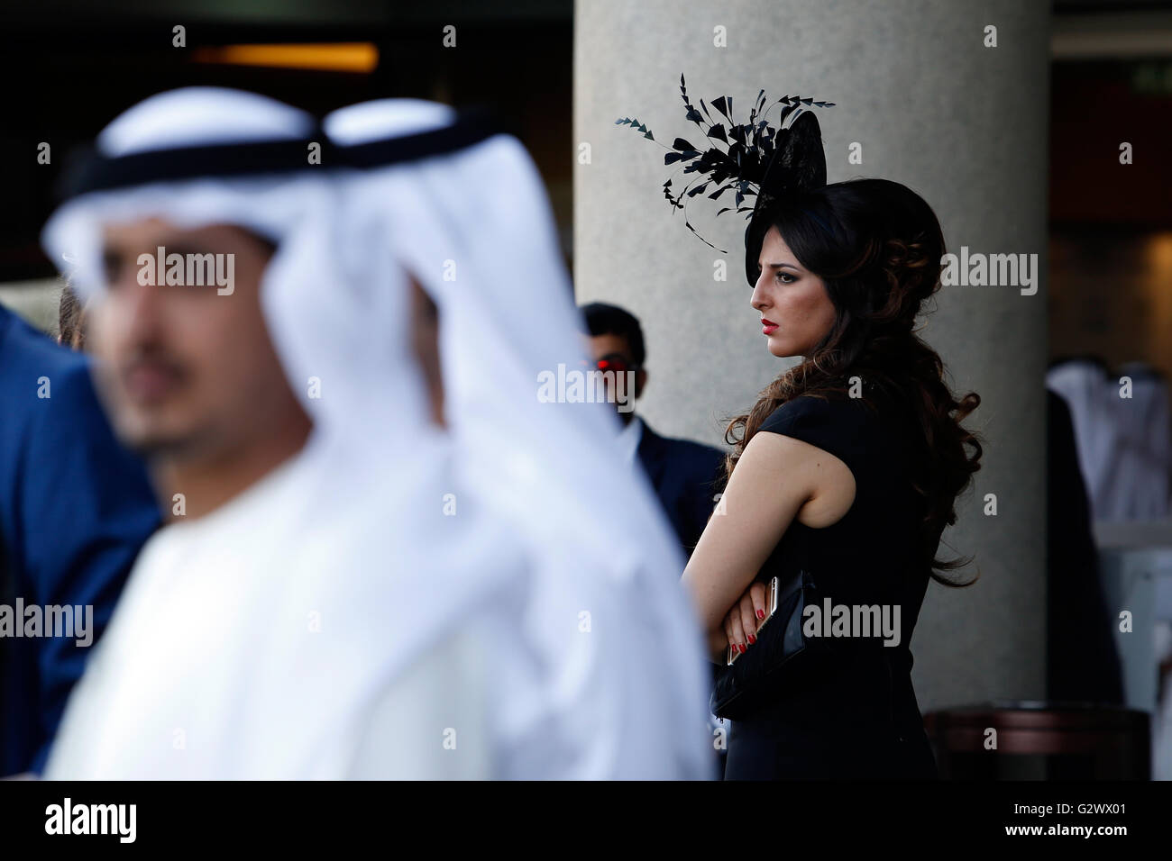 28.03.2015, Dubai, Dubai, Vereinigte Arabische Emirate - elegant gekleidete Frau mit Hut und Männer in Tracht bei den Rennen. 00S150328D711CAROEX. JPG - nicht für den Verkauf in G E R M A N Y, A U S T R I A S W I T Z E R L A N D [MODEL-RELEASE: Nein, PROPERTY-RELEASE: Nein, (C) Caro Fotoagentur / Sorge, http://www.caro-images.com, info@carofoto.pl - jegliche Nutzung dieses Bildes unterliegt GEMA!] Stockfoto