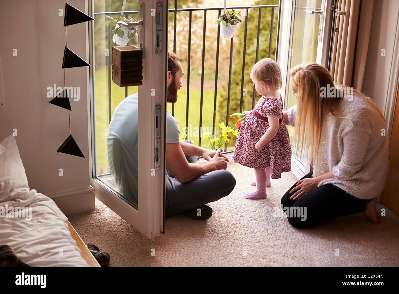 Familie zu Hause Bewässerung von Pflanzen auf Balkon Stockfoto