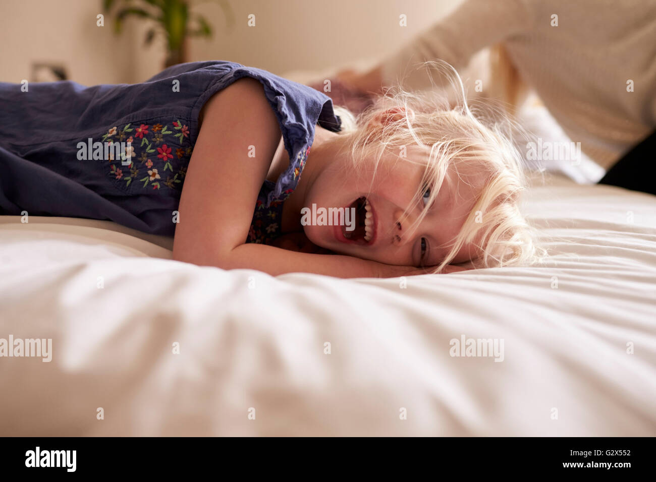 Porträt des jungen Mädchens liegend im Bett der Eltern Stockfoto