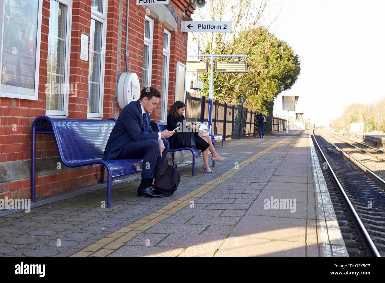 Pendler am Bahnsteig, die Benutzung von Mobiltelefonen Stockfoto
