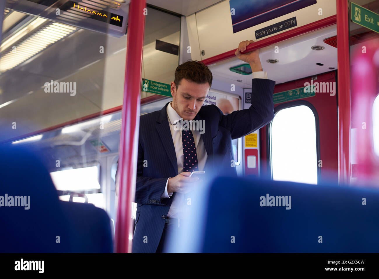 Geschäftsmann, die SMS-Nachricht auf Zug während pendeln lesen Stockfoto