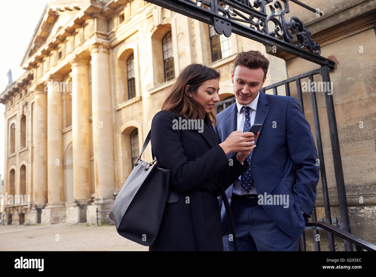 Kollegen nutzen Smartphone In Outdoor-City-Lage Stockfoto