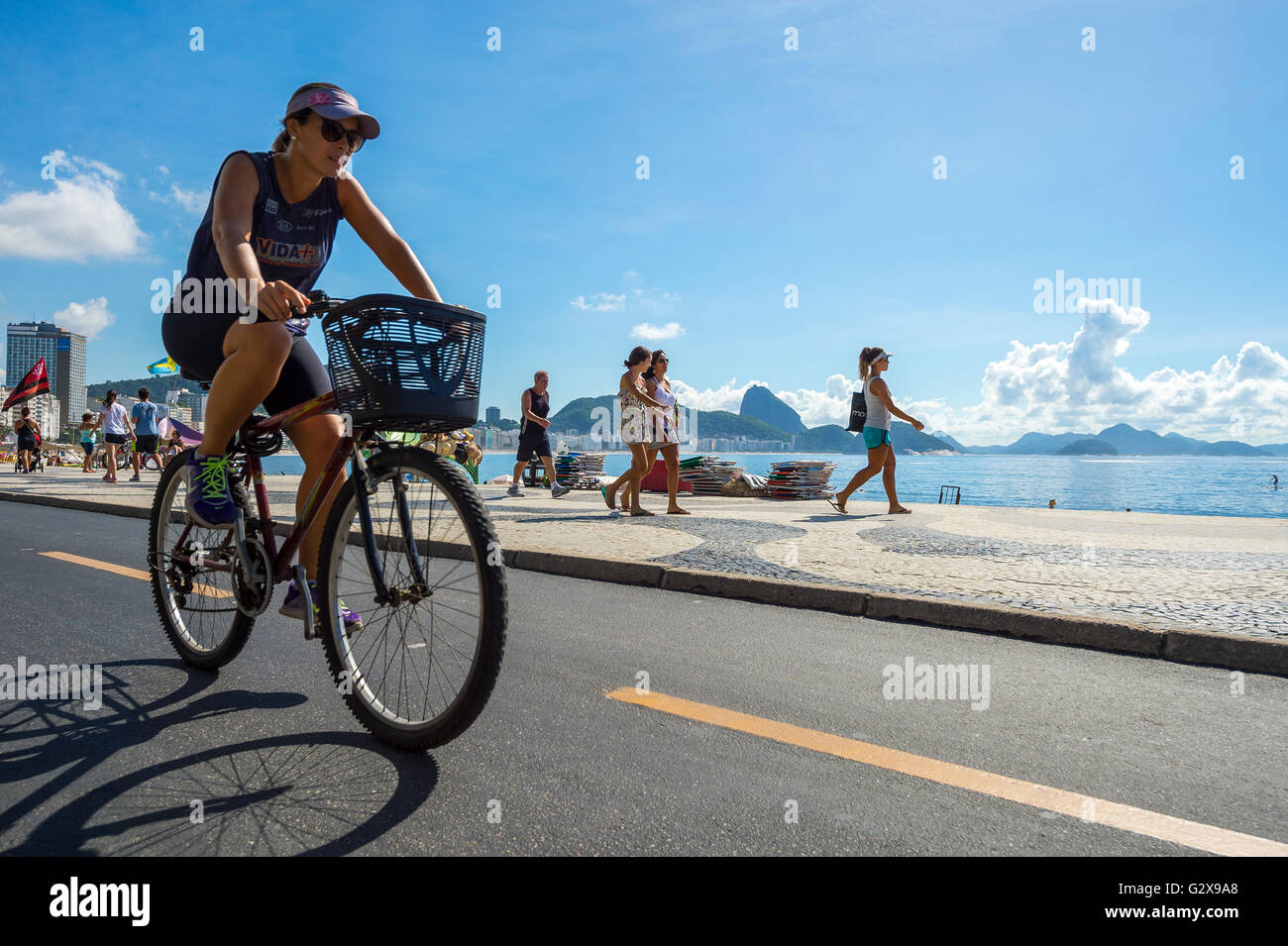 RIO DE JANEIRO - 20. März 2016: Eine brasilianische Frau fährt Fahrrad auf der Strandpromenade Avenida Atlântica Radweg in Copacabana. Stockfoto