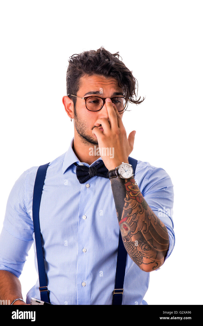 Porträt von schüchtern oder verlegen junger Mann in Gläsern, Fliege, Hosenträger und Hemd wegsehen. Studio gedreht Stockfoto