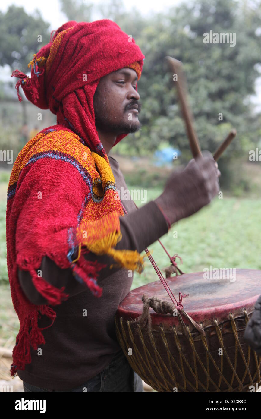 Mitglied einer Stammes-Gemeinschaft in Westbengalen, Schlagzeug zu spielen, während ihre Dorffest Stockfoto