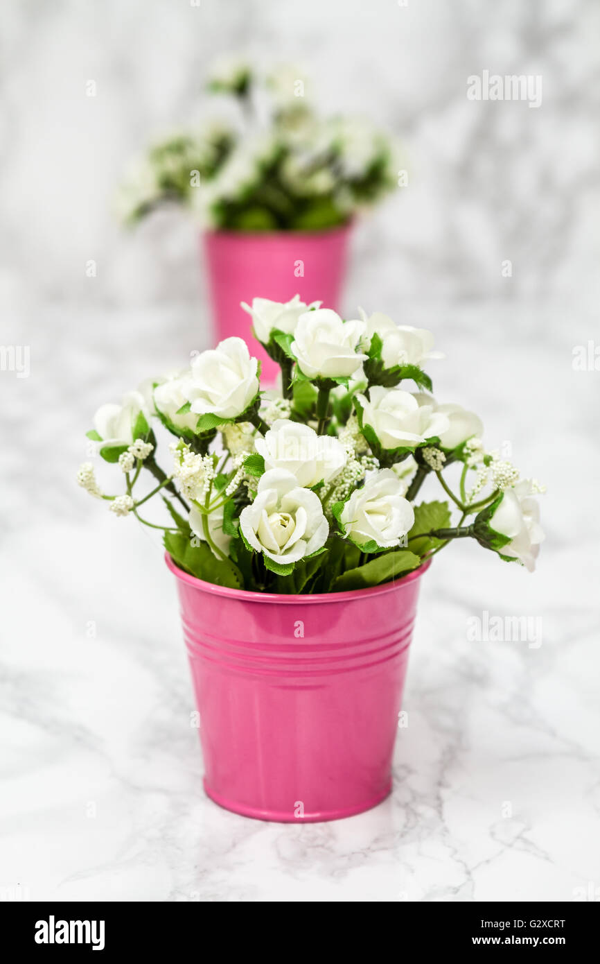 Kleine dekorative künstliche weiße Blumen in rosa Topf Stockfotografie -  Alamy