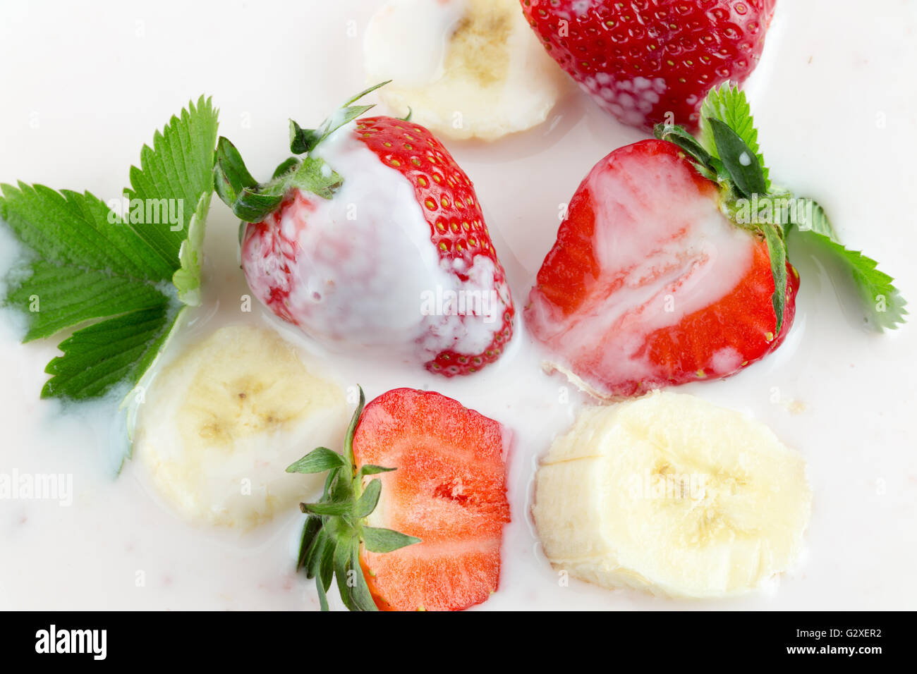 Erdbeeren und Bananenscheiben mit Sahne. Stockfoto