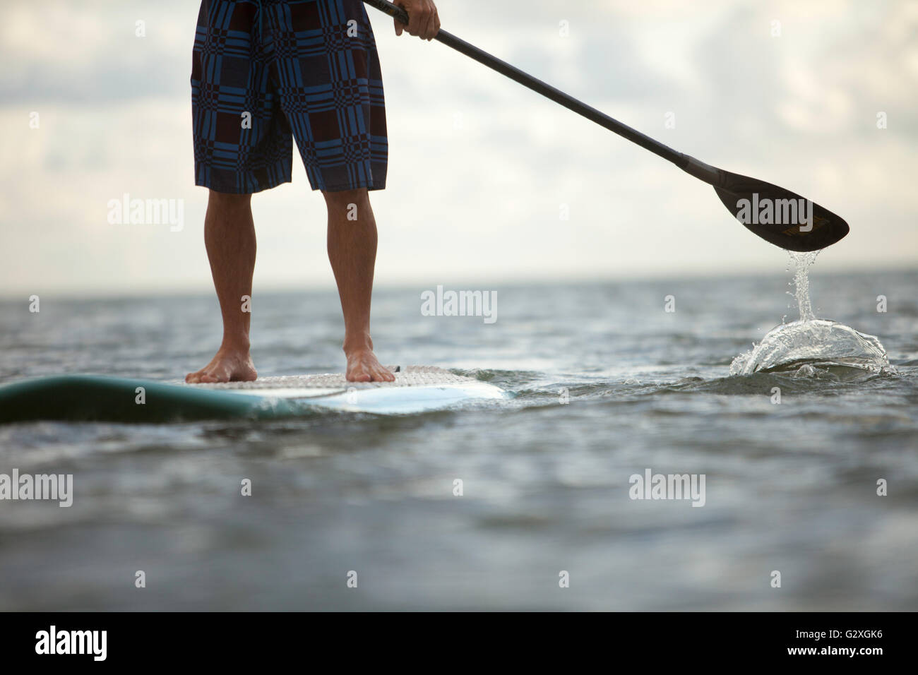 Ansichten von morgens aufstehen Paddle Board Sitzung in Kaneohe Bay, Brad Osborn paddeln tropischen Mischungen Board bei Sonnenaufgang. Stockfoto