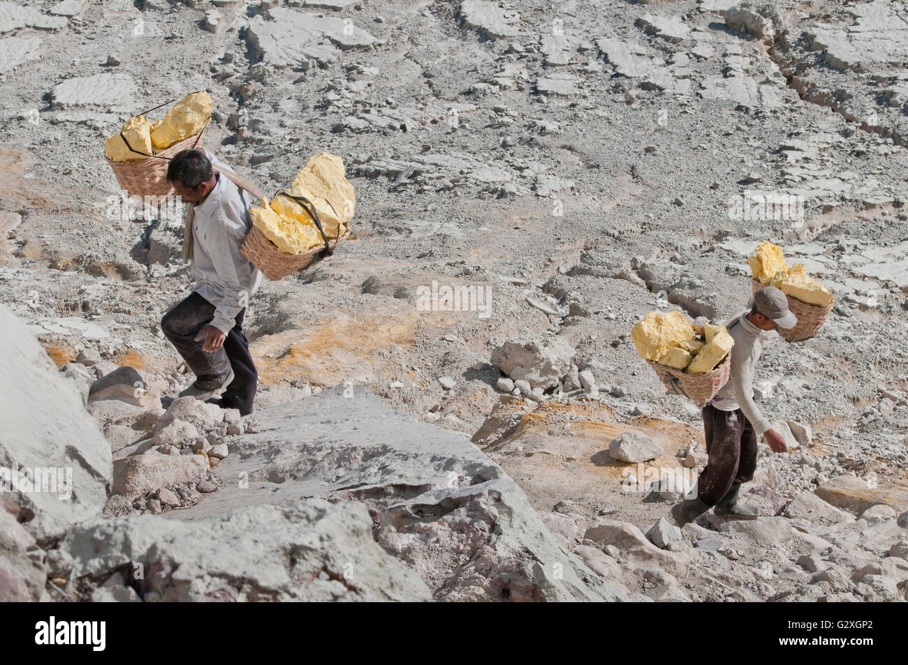 Java, Mt. Ijen, zwei männliche Arbeitnehmer tragen Schwefel Blocks vom Vulkan In zwei Körben Stockfoto
