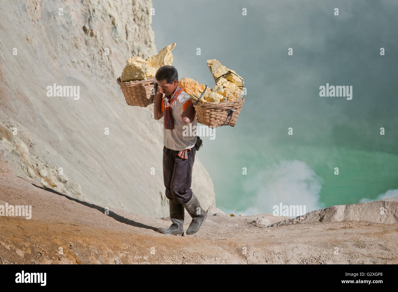 Java, Mt. Ijen, männlichen Arbeitnehmer tragen Schwefel Blocks vom Vulkan In zwei Körben Stockfoto