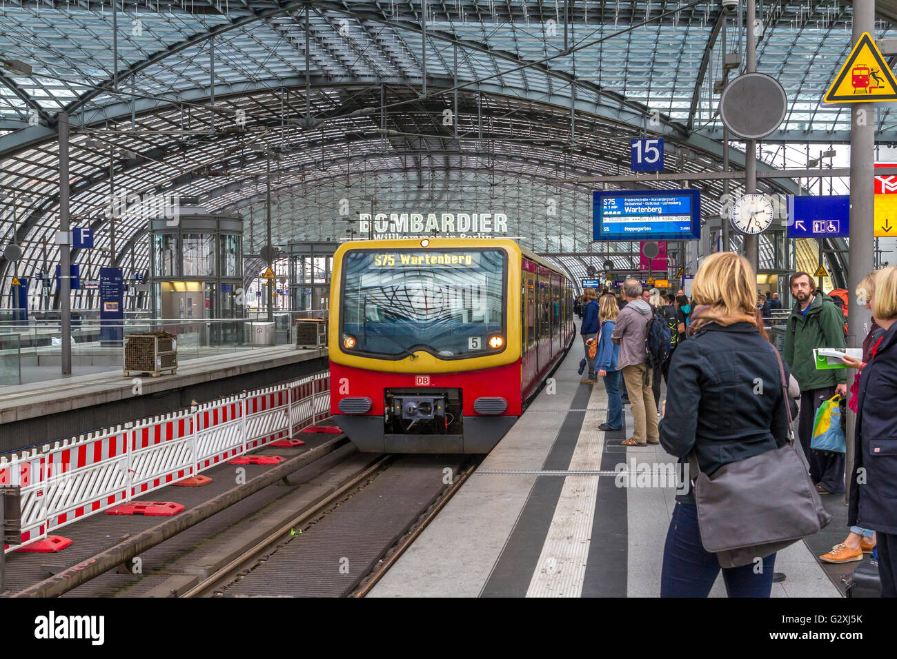 Passagiere, die auf dem Bahnsteig auf einen herannahenden S-Bahn-Zug am Berliner Hauptbahnhof, dem Hauptbahnhof in Berlin, warten Stockfoto