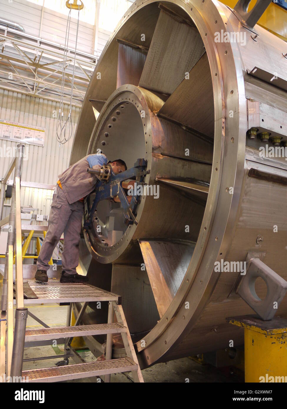 Arbeiter überprüfen eine Gasturbine während der Herstellung in eine französische Fabrik von General Electric in Belfort Stockfoto
