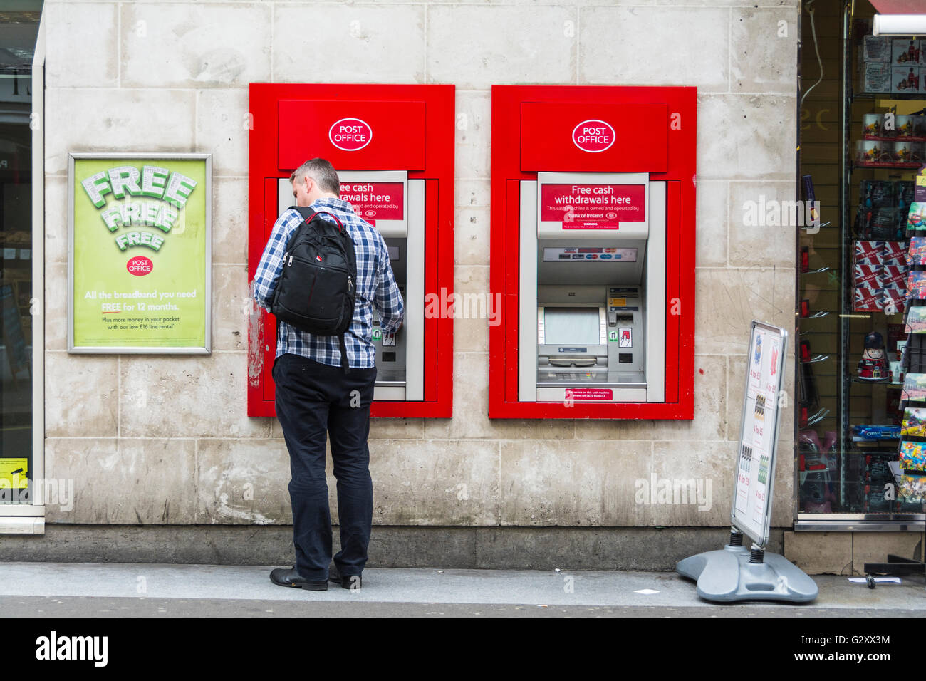 Ein einziger weißer Mann, der Bargeld von einem Geldautomaten in der Duncannon Street in der Nähe des Trafalgar Square in London, England, Großbritannien abzieht. Stockfoto