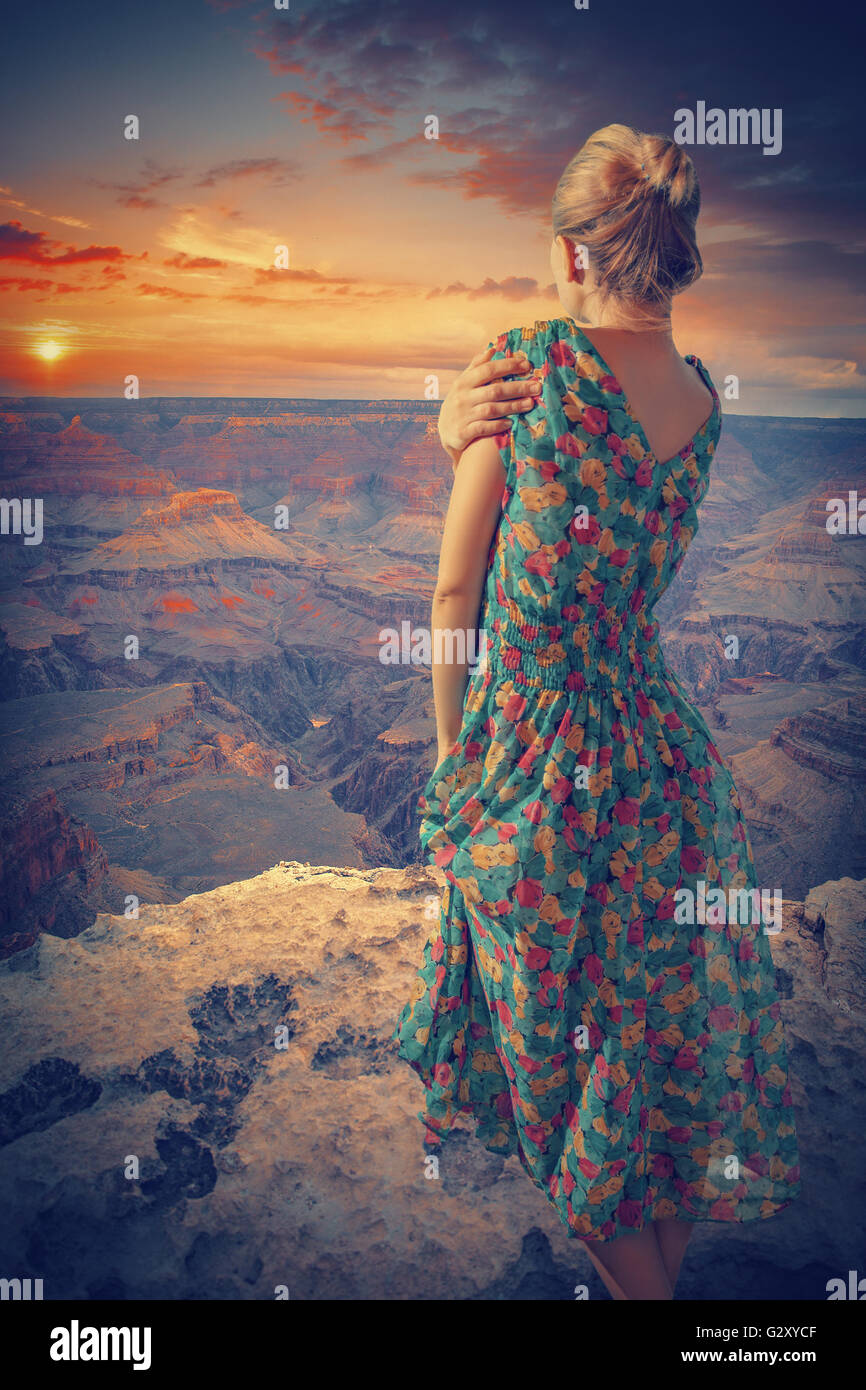 Frau im Kleid steht in den Grand Canyon. den Sonnenuntergang genießen. Vintage-Stil Stockfoto