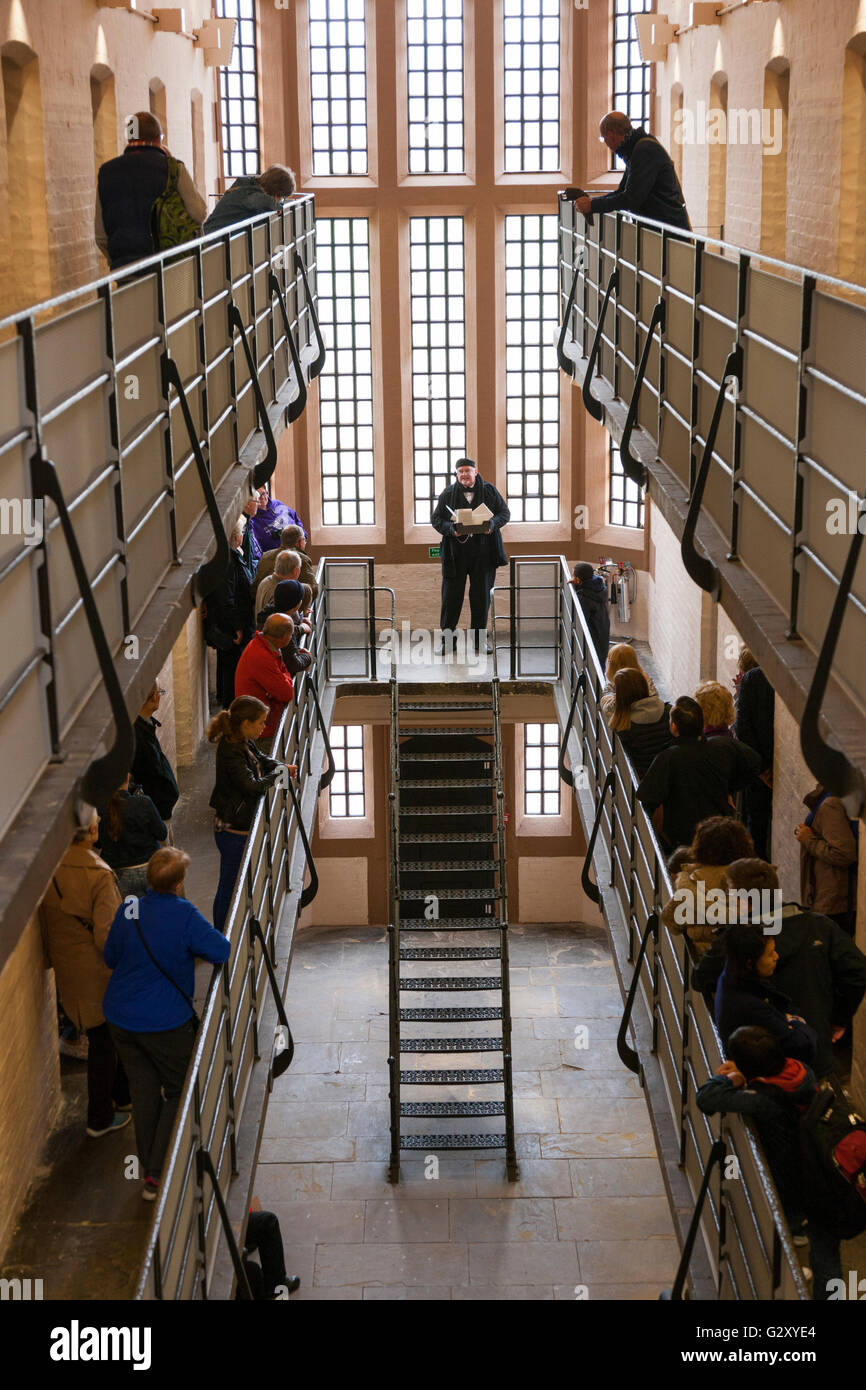 Führer in historischen Kleid / Rollenspiel spricht mit einer Reisegruppe / touristische Gruppen von Touristen in Lincoln Castle viktorianischen Gefängnis. Stockfoto