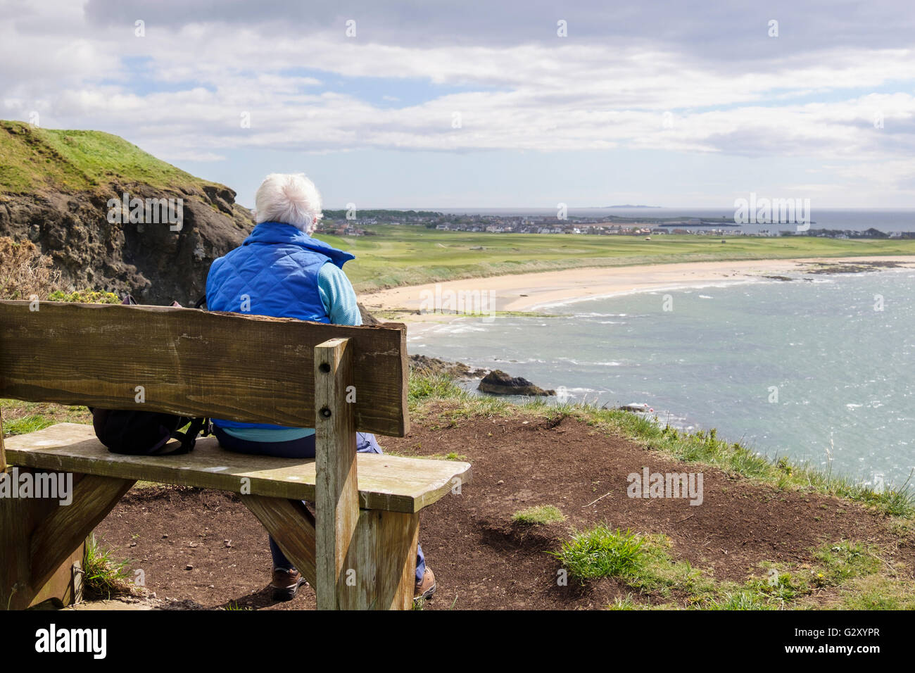 Pensionierte ältere Frau Rentner ruht auf einer Sitzbank von der Fife Coastal Path zu West Bay in Firth von weiter. Elie und Earlsferry Fife Schottland Großbritannien Stockfoto