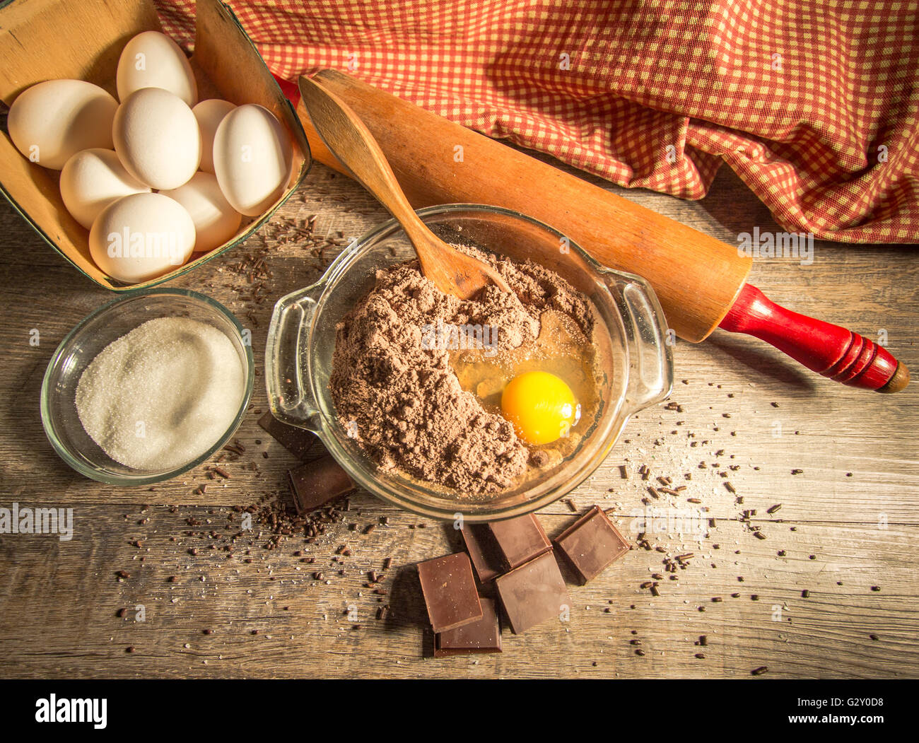 Schokolade Kuchen backen. Umgeben von frischen Zutaten, Holzlöffel und Schokolade Schokolade Kuchenteig vorbereiten. Stockfoto