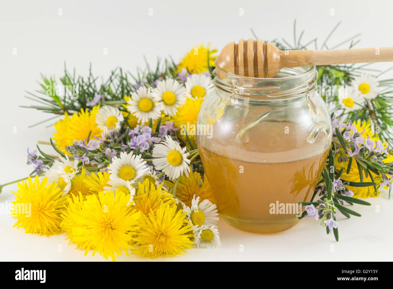Frische Blumen und ein Glas süßen Honig Stockfoto