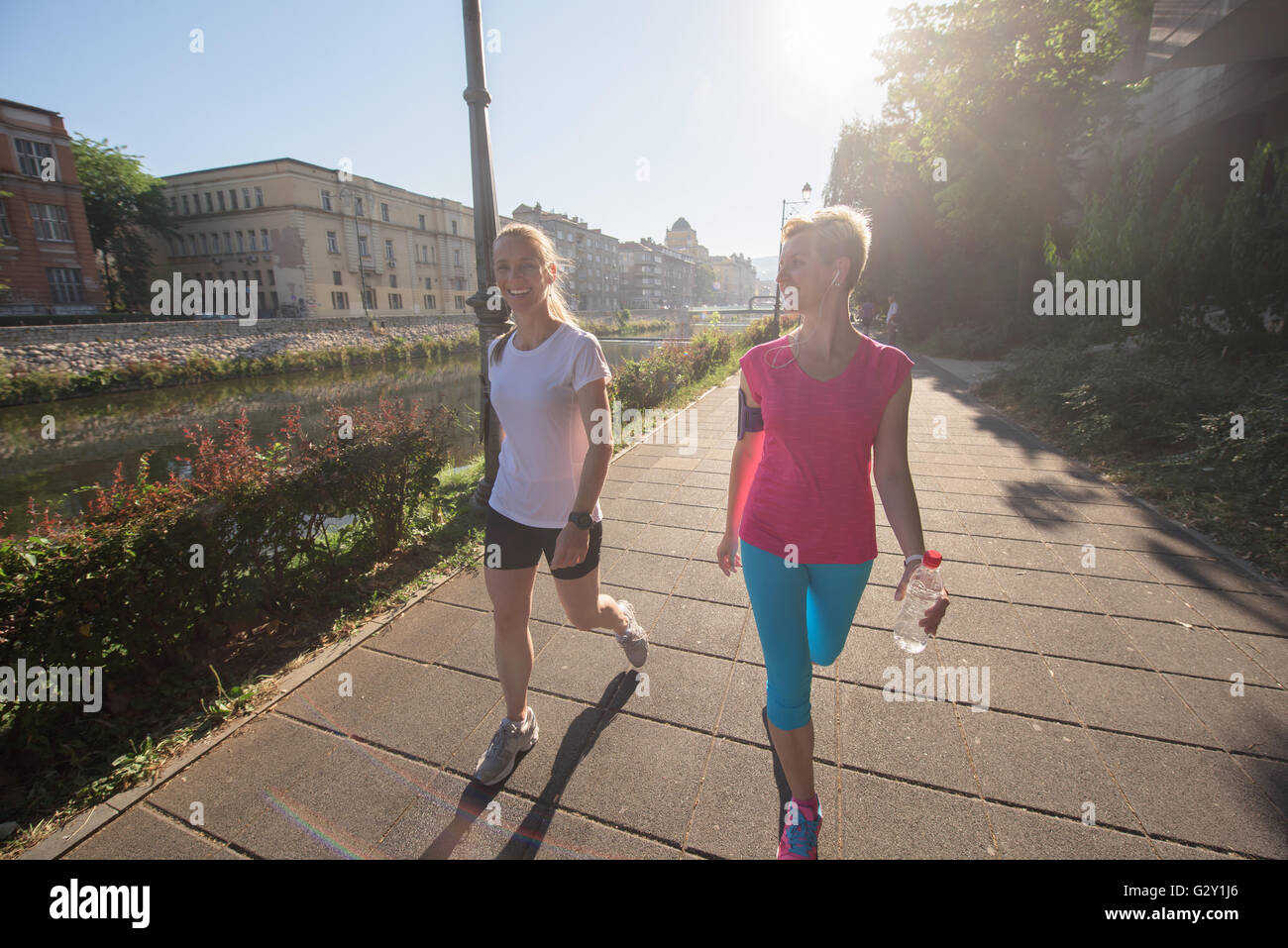 zwei Freundinnen der mittleren Alters, die Joggen haben Morgengymnastik mit Sonnenaufgang im Hintergrund Stockfoto