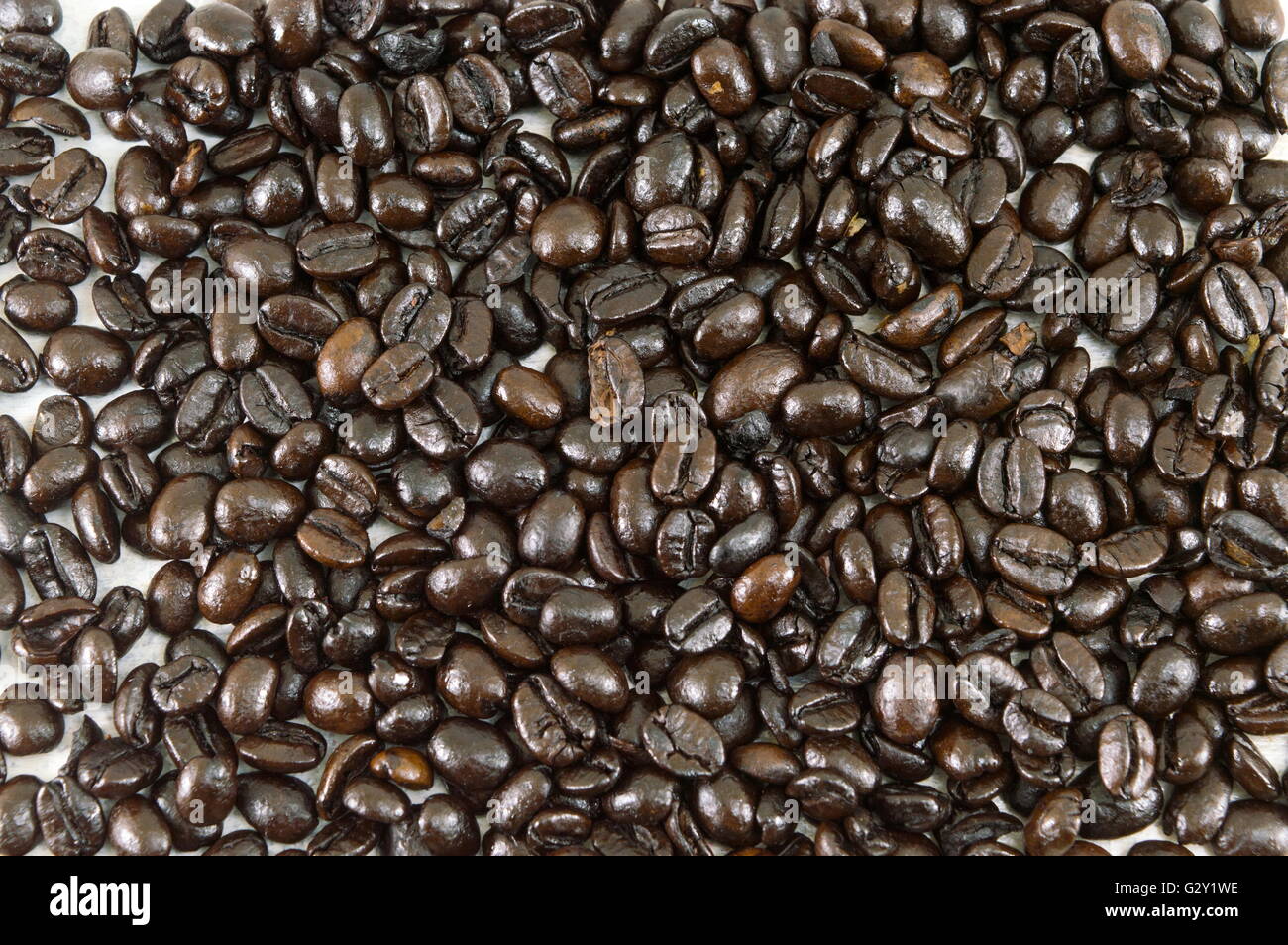 Handvoll geröstete Kaffeebohnen bilden Hintergrund Stockfoto