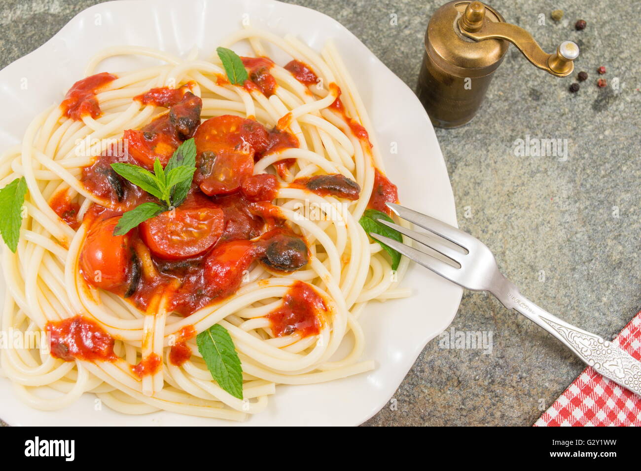 Spaghetti mit Ketchup, Käse, Gemüse und Petersilie serviert. Stockfoto
