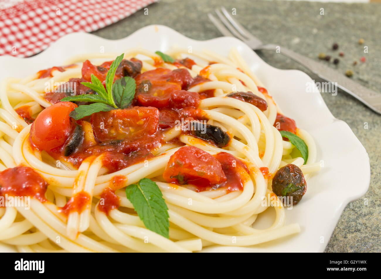 Spaghetti mit Ketchup, Käse, Gemüse und Petersilie serviert. Stockfoto