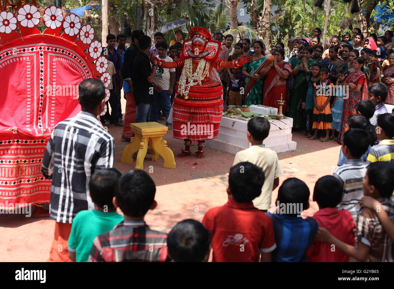 Theyyam ist eine rituelle Kunst Norden Keralas, hier die Performer Hänseleien mit Kindern Stockfoto