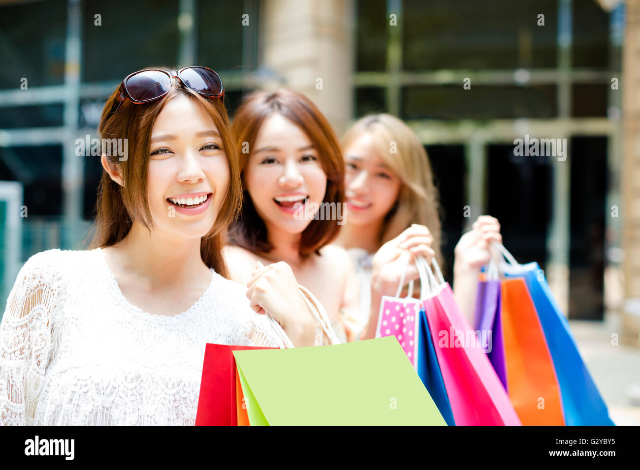 junge Frauen Gruppe tragen Einkaufstüten On Street Stockfoto