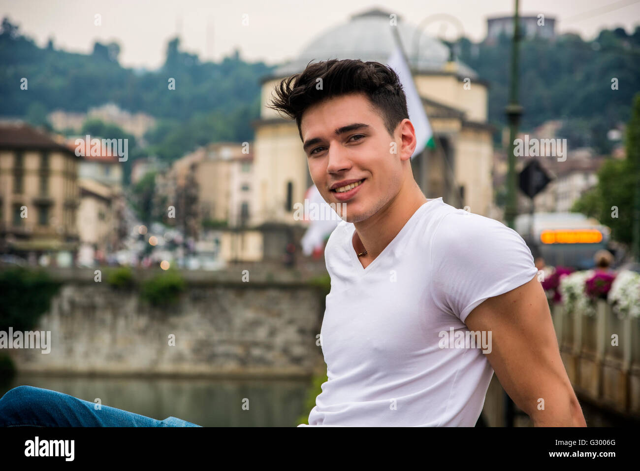 Hübscher junger Mann in Stadtstraße, Blick in die Kamera mit einem Lächeln Stockfoto