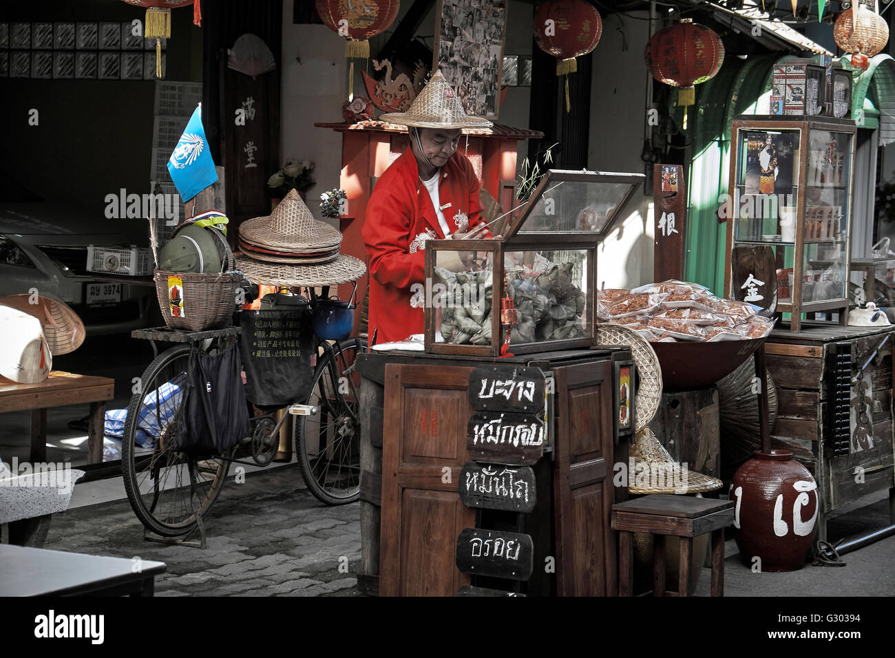 China Town Street Market Vendor in traditionellem Chinesisch-rotem Kostüm. Thailand S. E. Asien Stockfoto