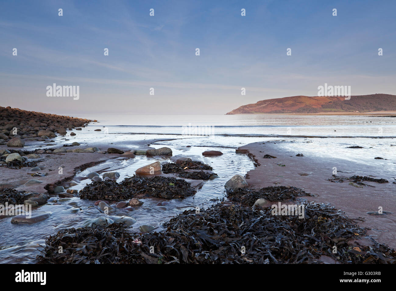 Strand in der Nähe Porlock Weir an der Kanalküste Bristol Suche entlang einem kleinen Bach in den Sand in Richtung Bossington Hügel, England Stockfoto