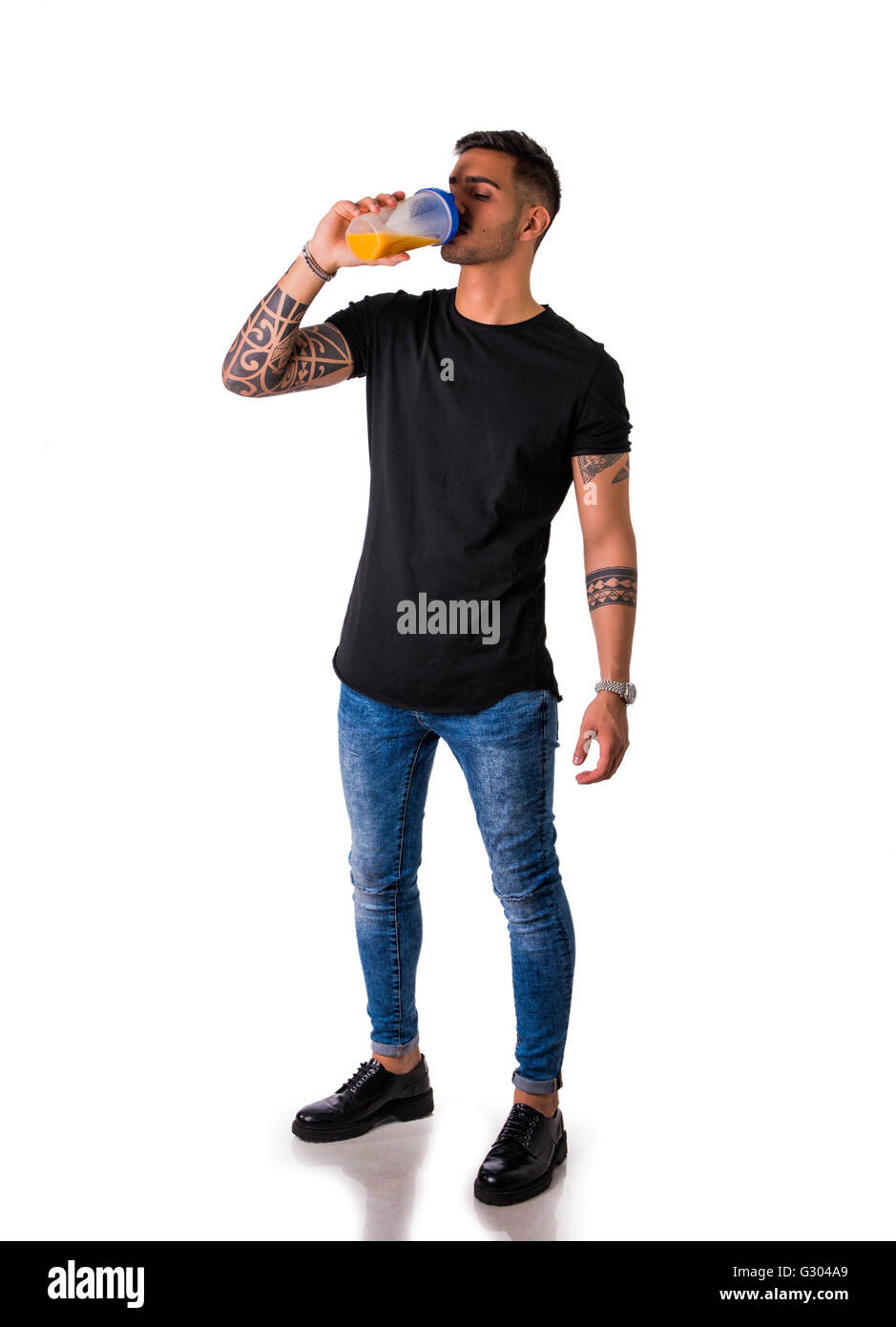 Attraktive junge Mann oder Teenager trinken Protein-Shake aus der Flasche. Isoliert auf weiss. Voller Länge Körper Schuss Stockfoto