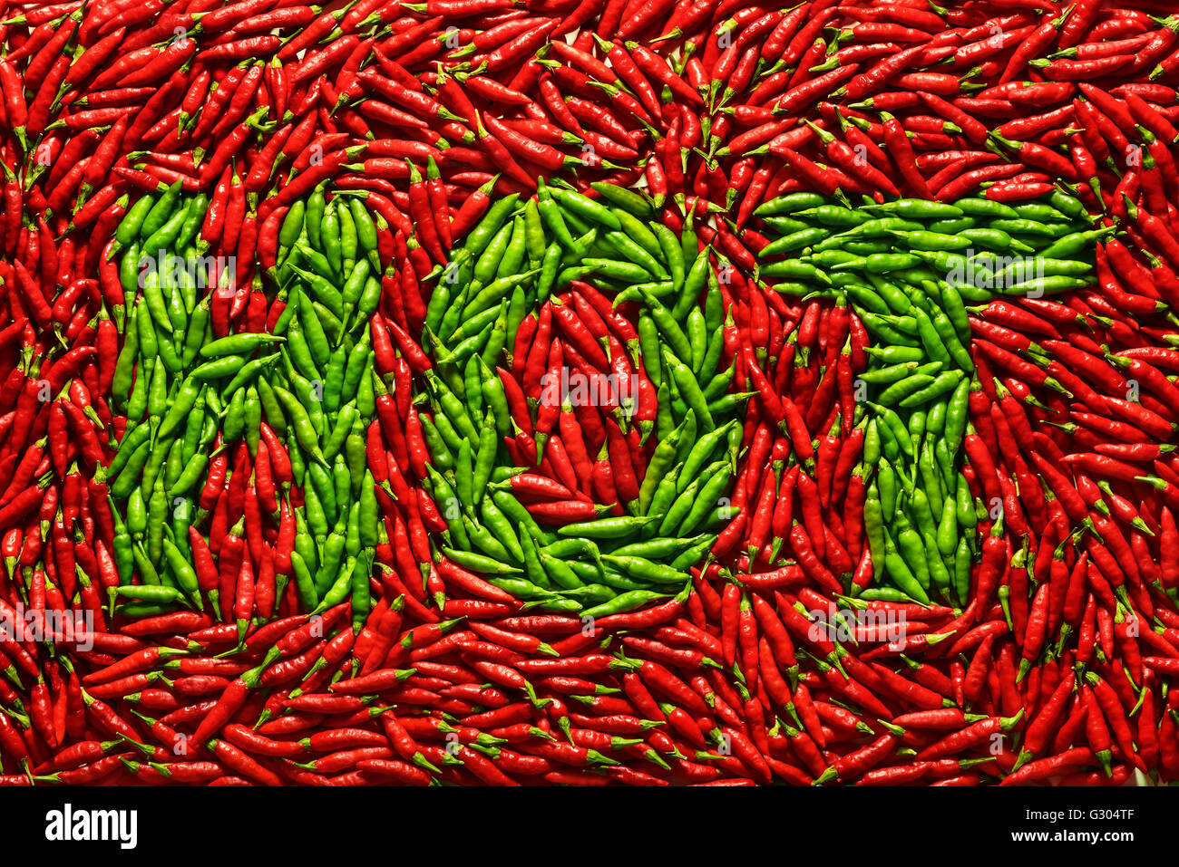 Rote Chilischoten mit dem Wort Hot in grüner Schrift. Stockfoto