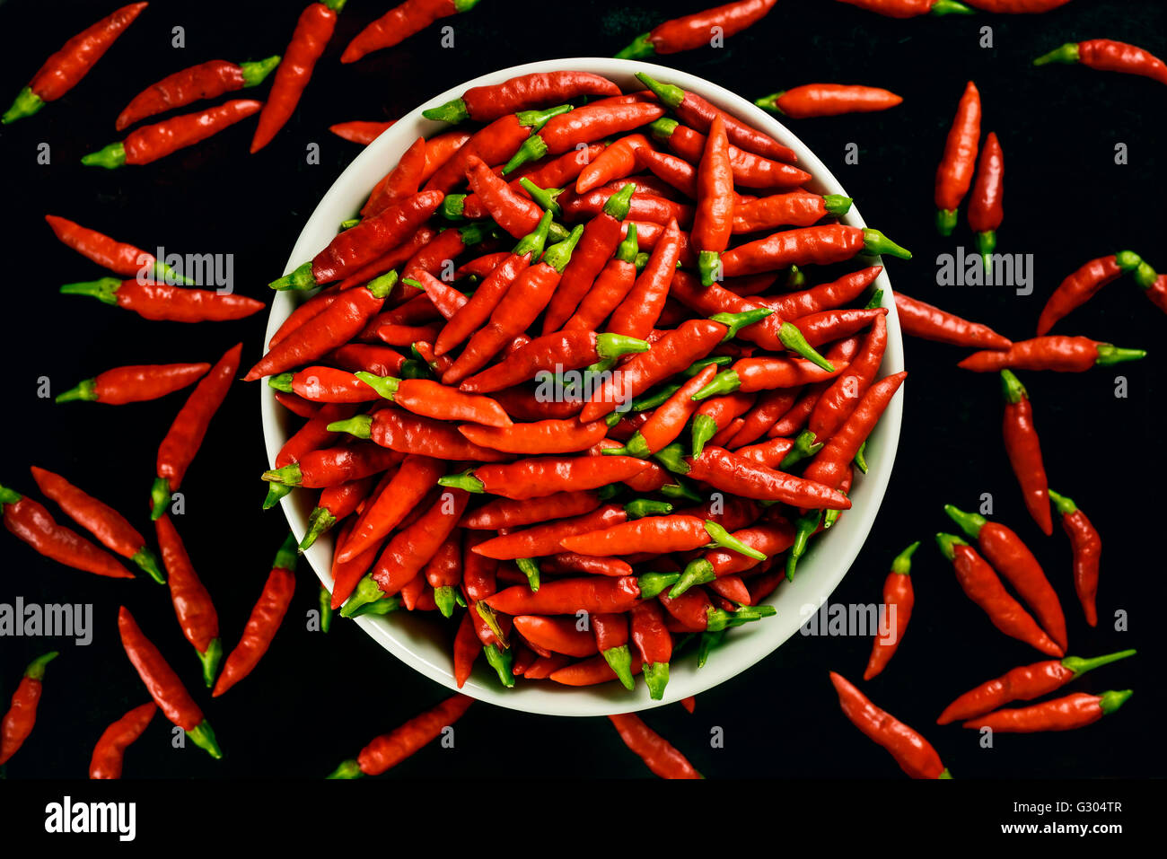 Rote Chilis vor einem schwarzen Hintergrund. Stockfoto