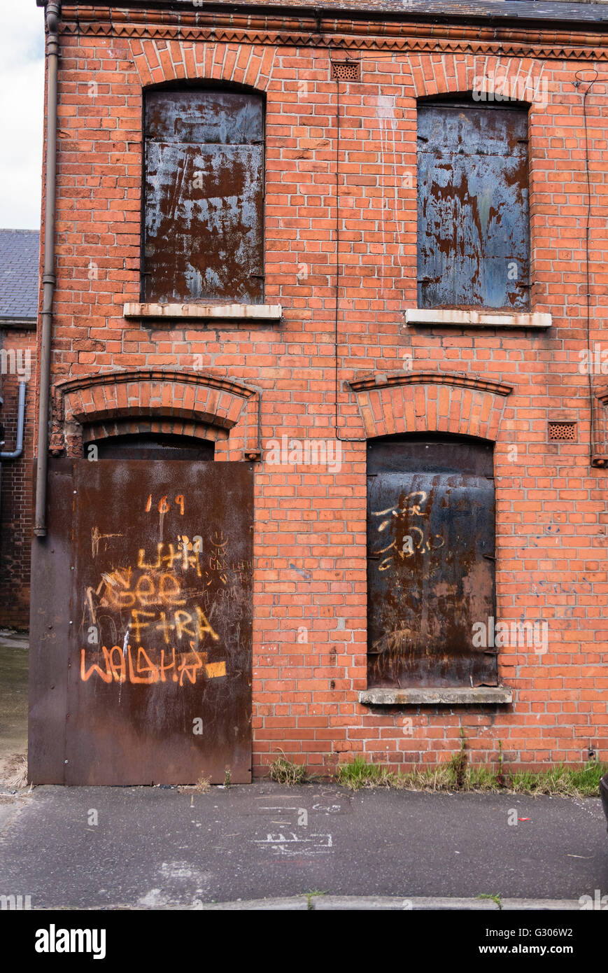 Verfallenes Haus mit Stahlplatten mit Brettern vernagelt. Stockfoto