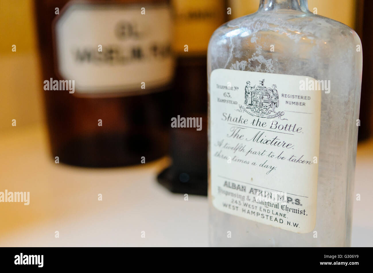 Flaschen in den Regalen in einer Arztpraxis von WW1 darunter eine von Alban Atkin, West Hampstead, England Stockfoto