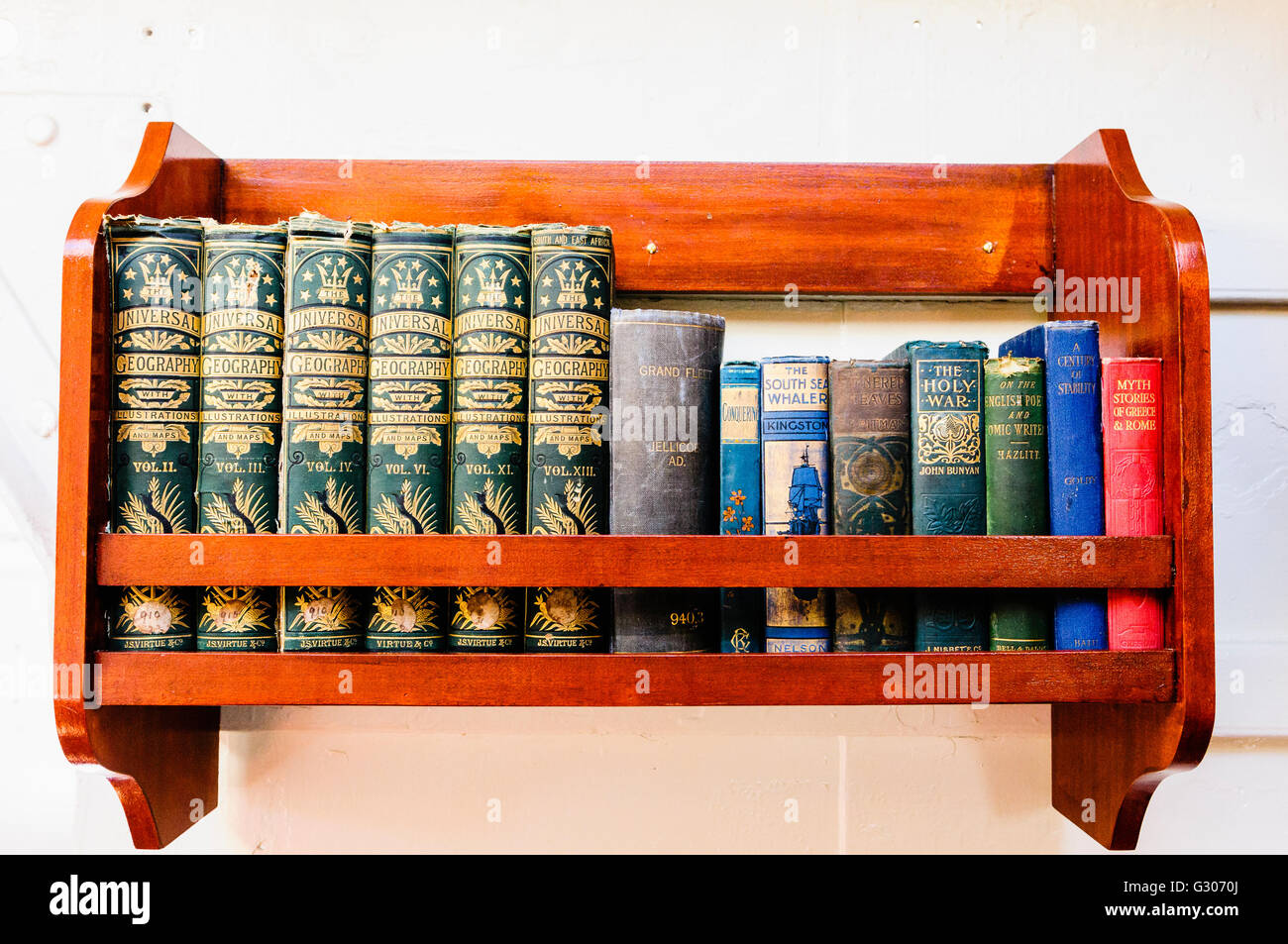 Kleines Bücherregal mit alten Büchern von um 1900-1915, einschließlich Universal Geography, Mythos Geschichten von Griechenland und Rom, und andere Stockfoto