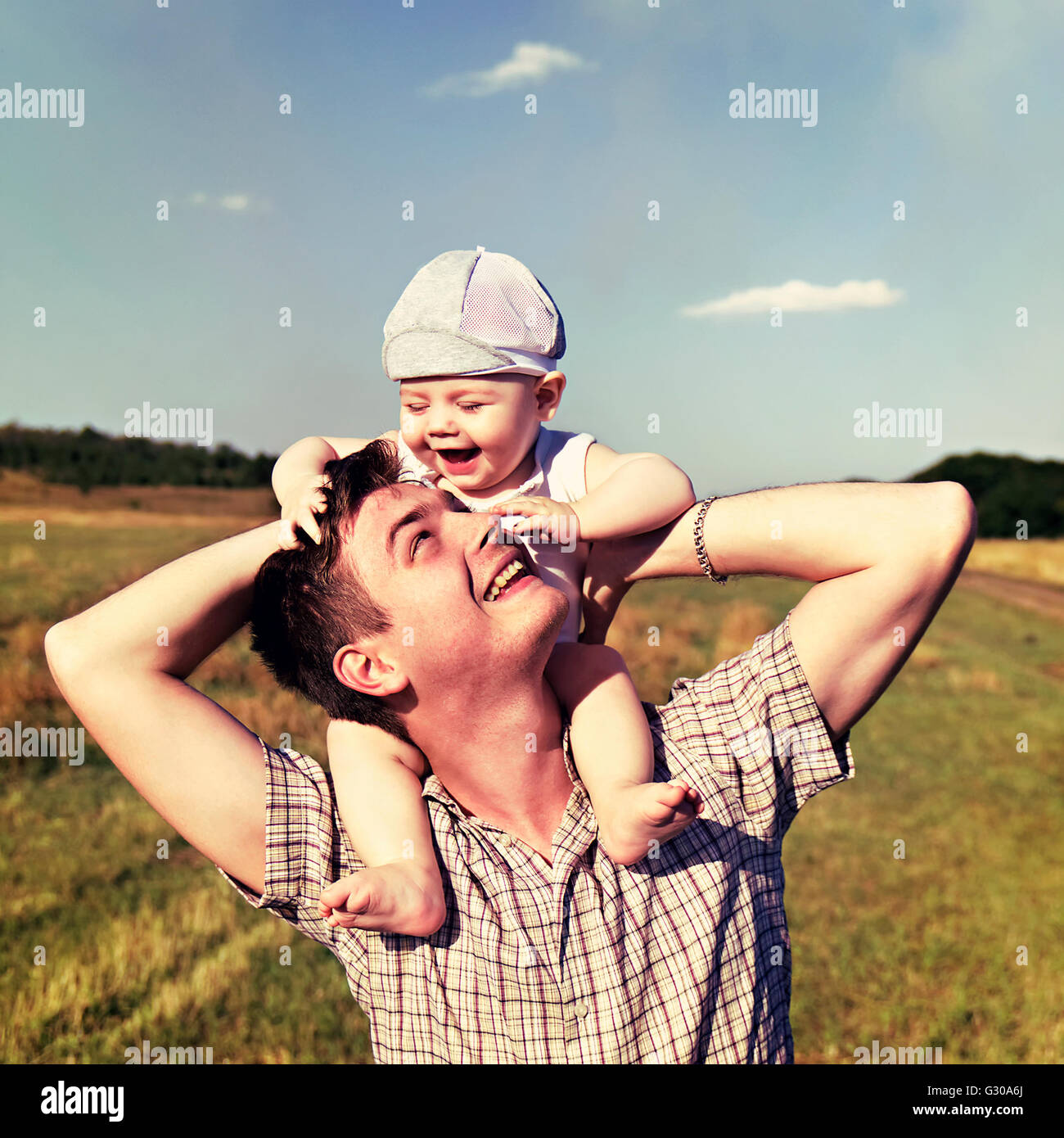 Vater hält ein kleines Kind auf seinen Schultern Stockfoto