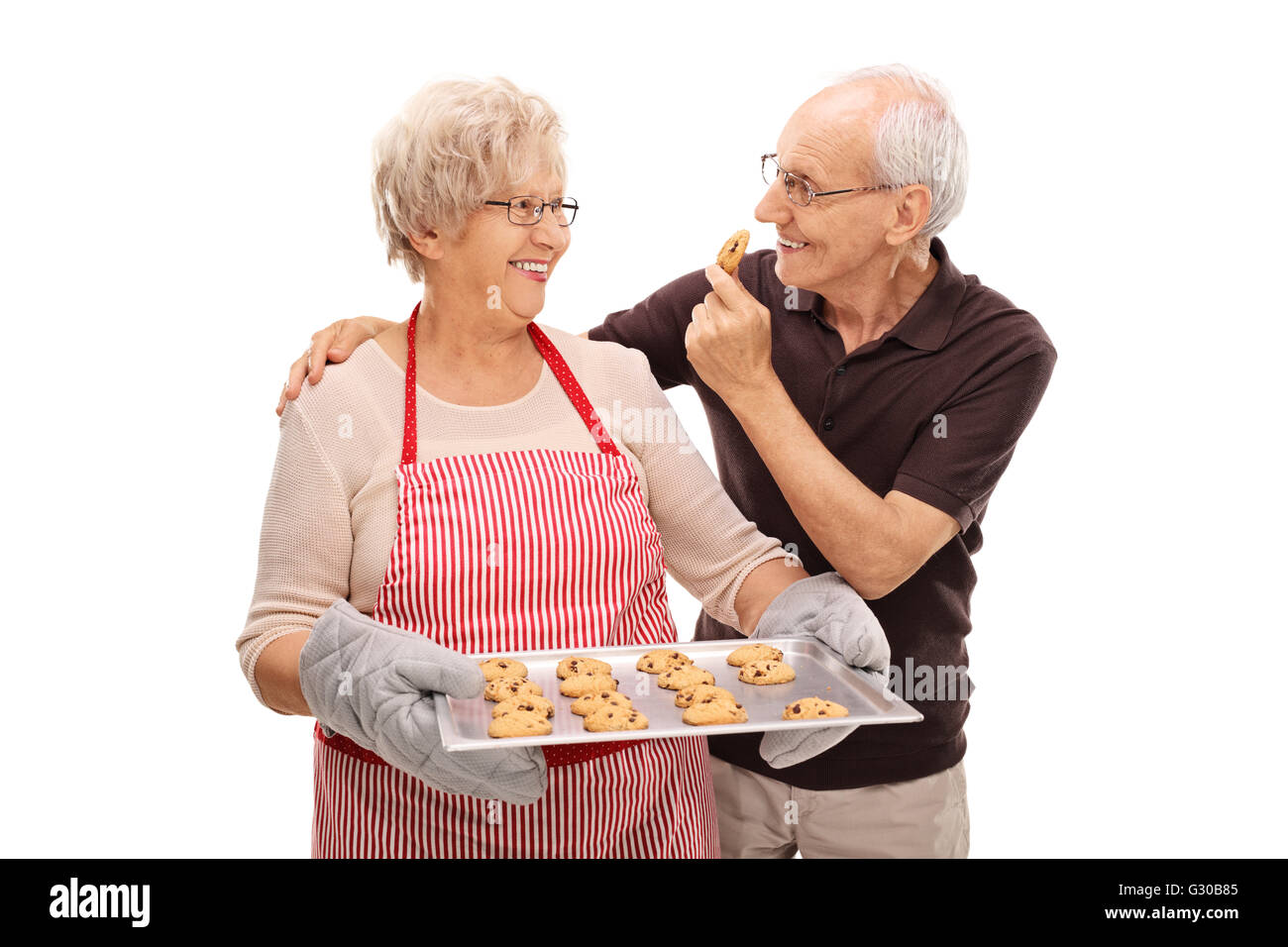 Älteres Ehepaar Essen hausgemachte Schokoladenkekse isoliert auf weißem Hintergrund Stockfoto