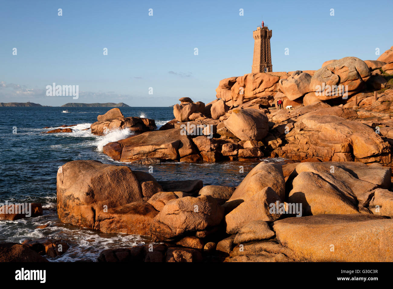 Leuchtturm und rosa Felsen bei Sonnenuntergang, Ploumanach, Cote de Granit Rose, Côtes d ' Armor, Bretagne, Frankreich Stockfoto