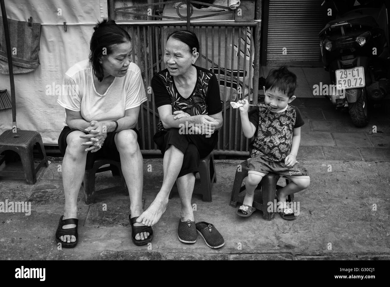 Zwei vietnamesische Frau mit einem kleinen Kind sprechen während der Sitzung von der Bahnstrecke in Hanoi, Vietnam. Stockfoto
