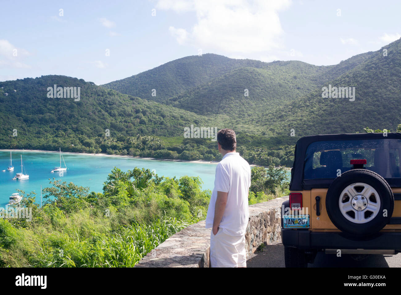 Mann, der in die Landschaft und Maho Bay von einem Aussichtspunkt auf St. John, US Virgin Islands Stockfoto