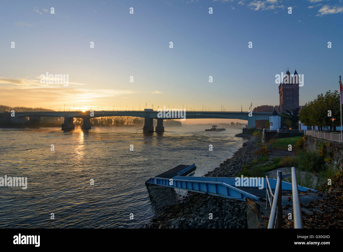 Fluss Rhein (Rhein) bei Sonnenaufgang mit Nibelungenbrücke, Nibelungen-Turm, Frachtschiff, Deutschland, Rheinland-Pfalz, Worms Stockfoto