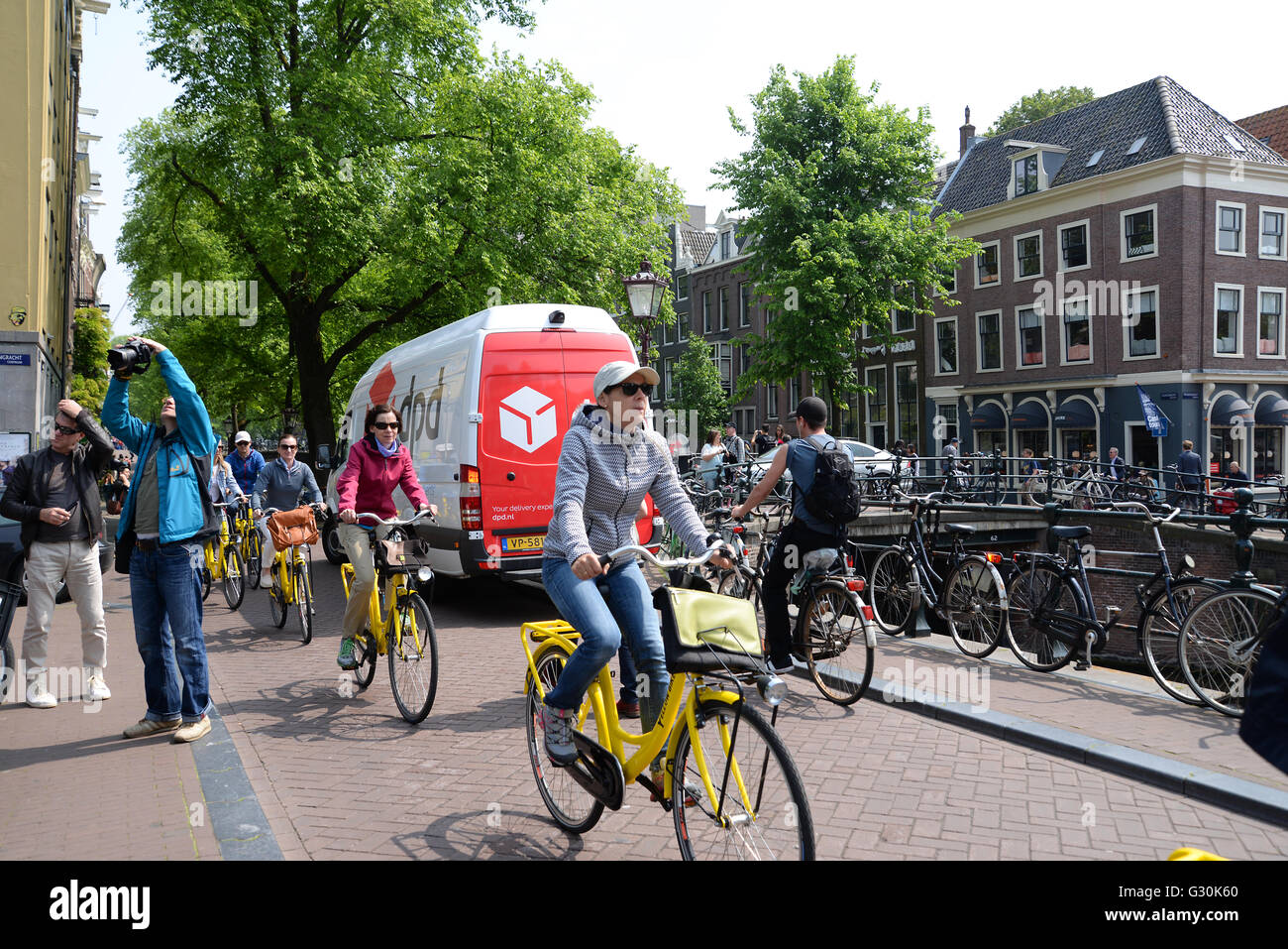 Radfahrer in der Stadt Amsterdam Fahrrad fahren entlang Kanal Straße auf  hellen gelben vermietet Fahrräder Stockfotografie - Alamy
