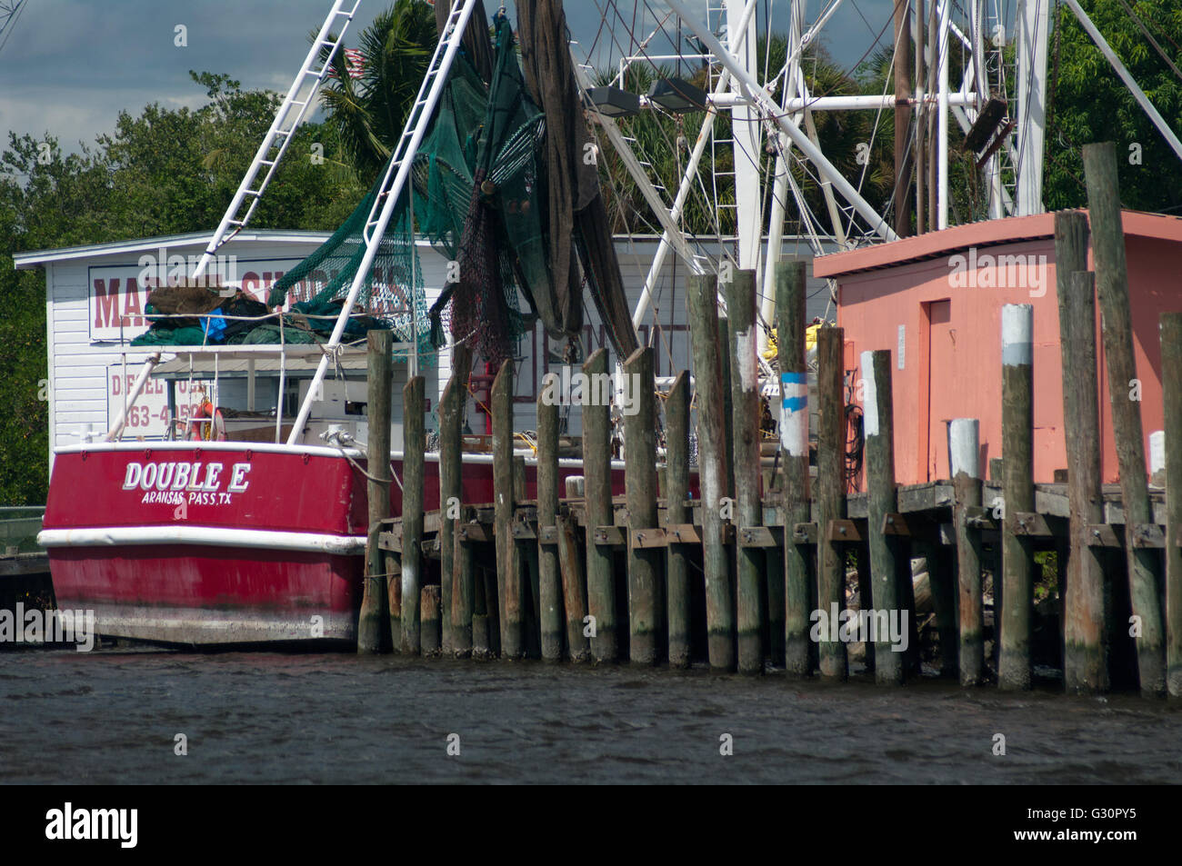 Eine kommerzielle Fischereifahrzeug liegt in der Nähe von einem rustikalen Dock in einer Marina in Fort Myers Beach, Florida, USA. Stockfoto