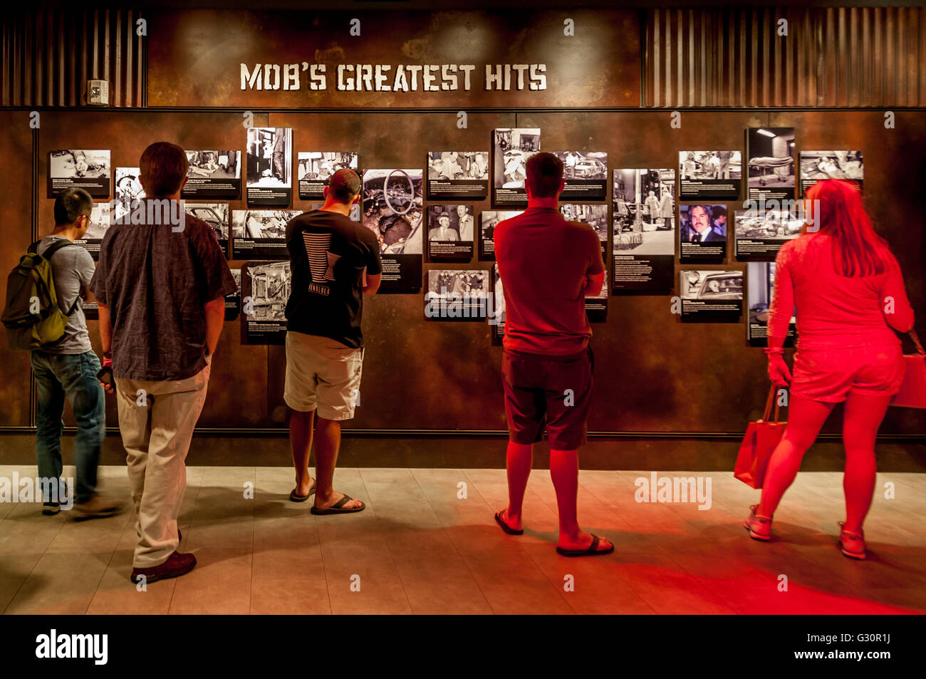 Besucher der Las Vegas Mob Museum nehmen in der Mob Greatest Hits Wand mit schrecklichen historischen Verbrechen-Szene-Fotos und Berichte. Stockfoto